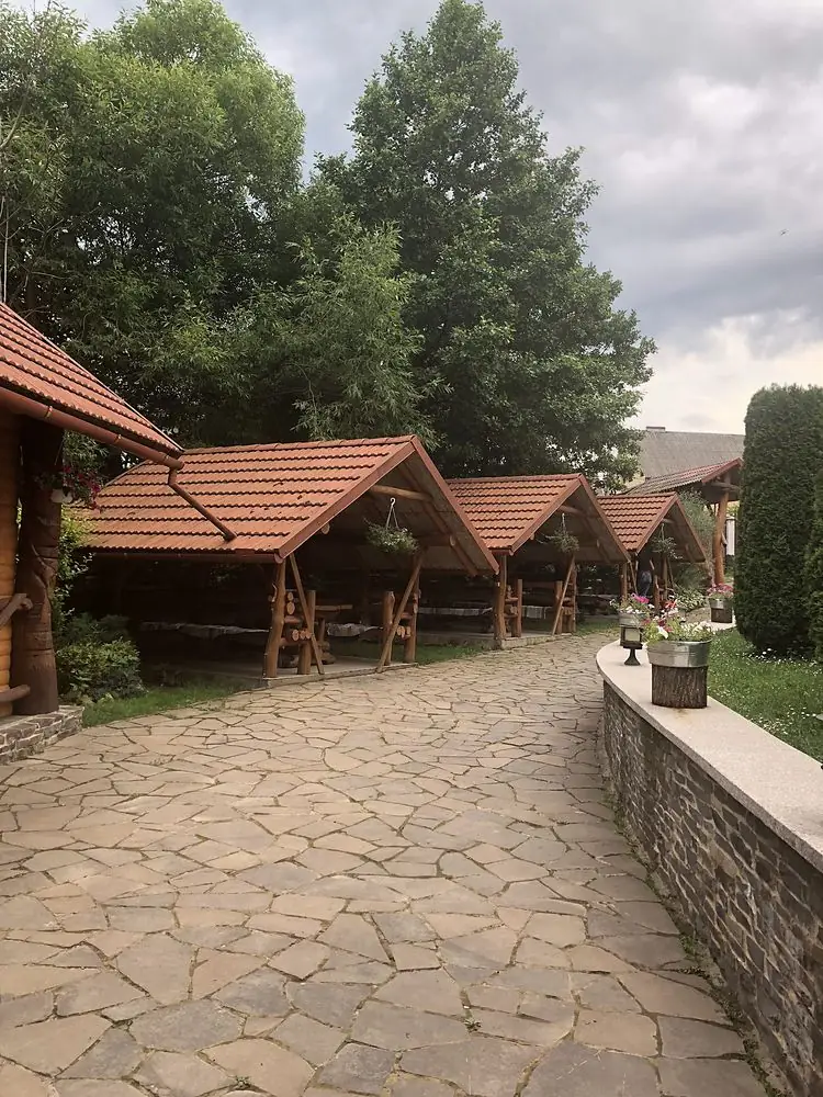 Ряд дерев'яних альтанок уздовж кам'яної доріжки