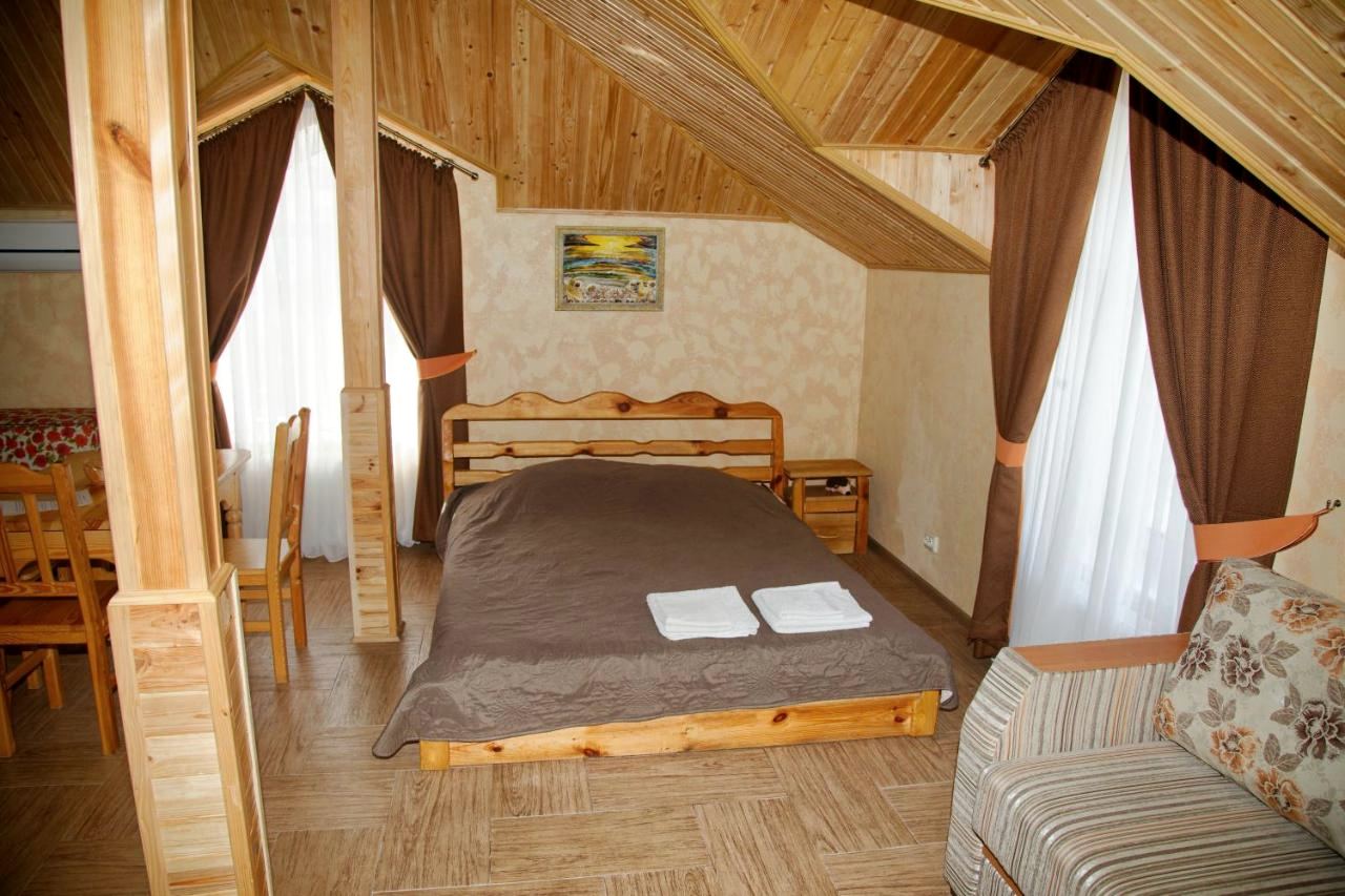 Двоспальне ліжко з рушниками між дерев’яними колонами